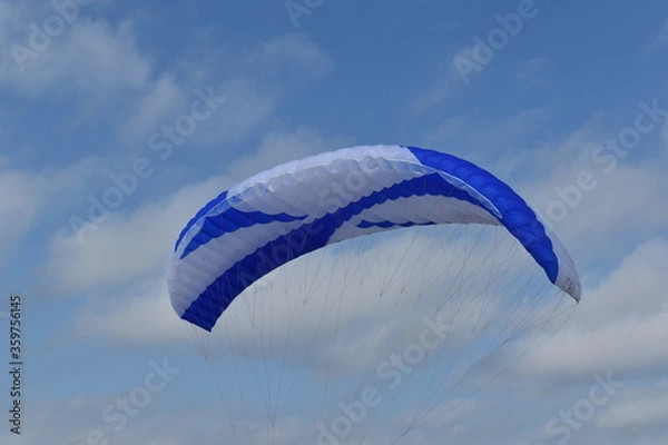 Fototapeta Paragliding at the beach of Katwijk aan Zee. Paraglider's making use of updraft of the dunes to stay in the air