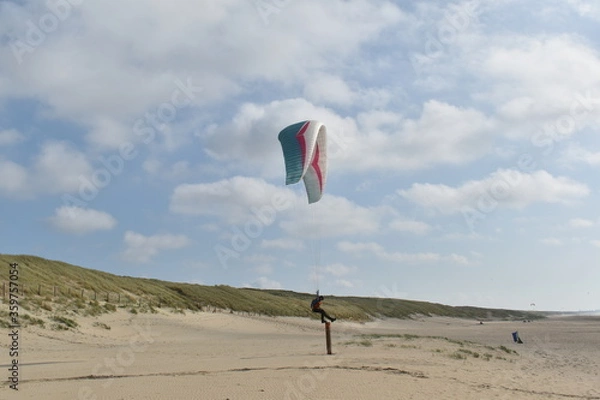 Fototapeta Paragliding at the beach of Katwijk aan Zee. Paraglider's making use of updraft of the dunes to stay in the air