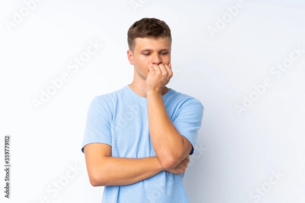 Fototapeta Young handsome man over isolated white background having doubts