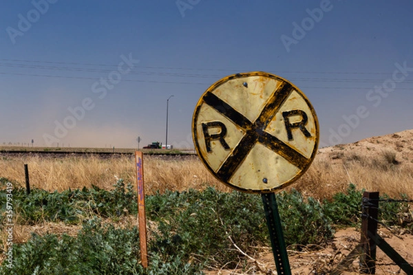 Obraz Battered old railroad crossing sign on a country road on the prairie