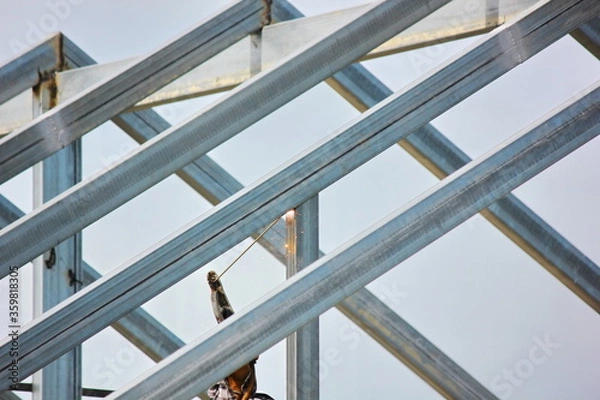 Obraz the worker welding metal on roof structure