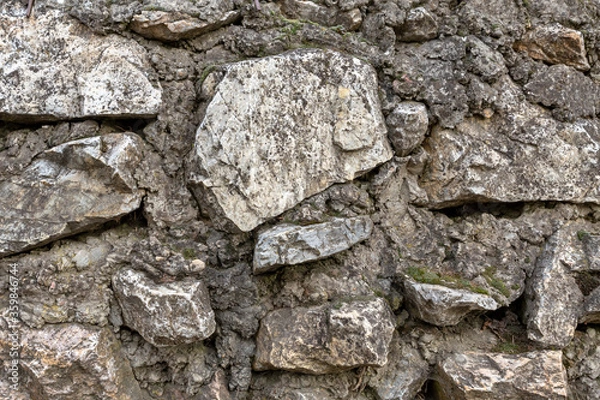 Fototapeta stone wall folded from solid cobblestone gray and weathered background base