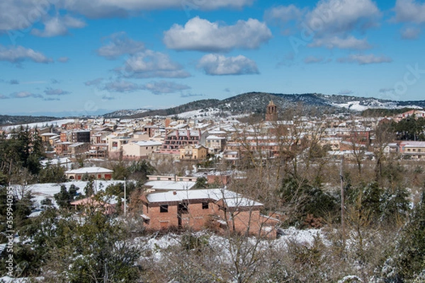 Fototapeta Postcard of the medieval town of Prades (in Catalonia, Spain) full of snow, with the church of Santa María and its typical fountain
