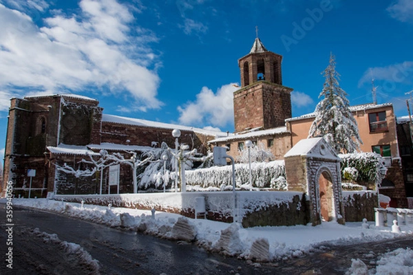 Fototapeta Postcard of the medieval town of Prades (in Catalonia, Spain) full of snow, with the church of Santa María and its typical fountain