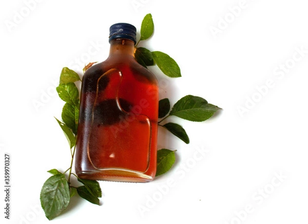 Obraz Flat bottle with oil and green leaves on white background