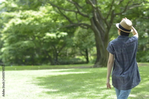 Fototapeta Asian young women.  like spending time in the middle of nature.   wear a hat at a rakish angle.  blurred background with copy space.