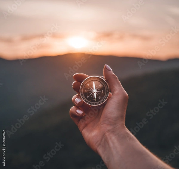 Fototapeta Ręka kobiety z kompasem magnetycznym w górach latem o wschodzie słońca, pov.