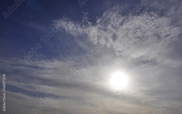 Obraz Panorama of the sunny sky. The sun in the haze of cirrostratus clouds. Signs of weather changes in the Western Urals.