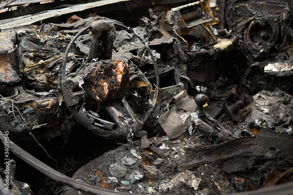 Fototapeta Completely burned out and melted sportscar cockpit wreck by arson vandalism in Berlin, Germany.