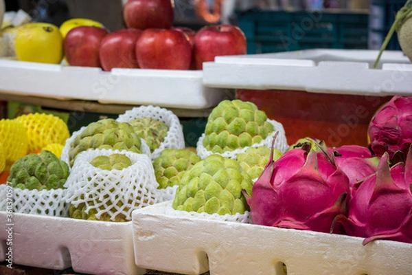 Obraz バンレイシやドラゴンフルーツなど色鮮やかなトロピカルフルーツが並ぶ南国の市場の青果店