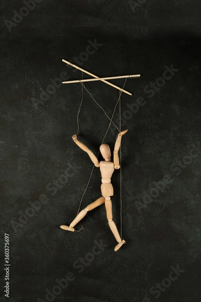 Obraz Puppet in the hands of puppeteer walks on isolated, background. The concept of manipulation. Copy space.