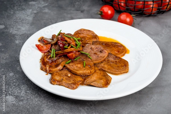 Fototapeta Beef tongue with sauce and vegetables on a white plate