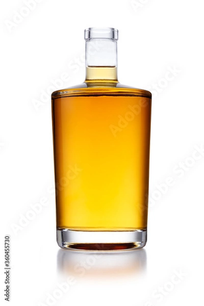 Fototapeta A full angular shaped bottle of golden whisky, with no label or branding, isolated on white