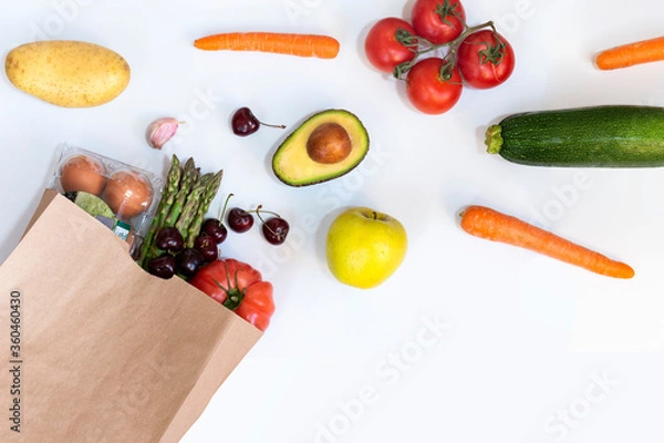 Fototapeta Paper bag of different healthy foods on a white background. Top view with copy space. Flat view.