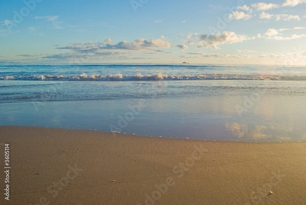 Fototapeta a nice beach scene with gentle waves reaching the sand