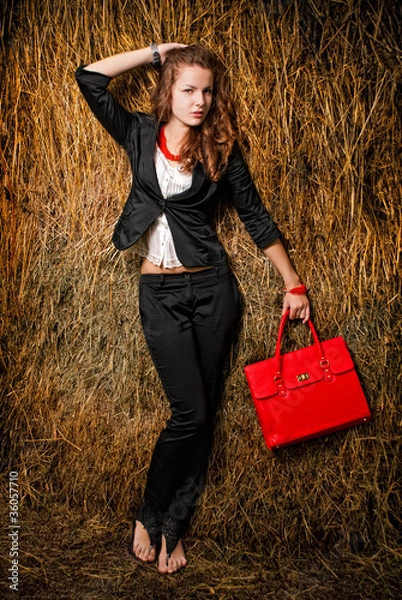 Fototapeta Young womans portrait holding red bag in hand.