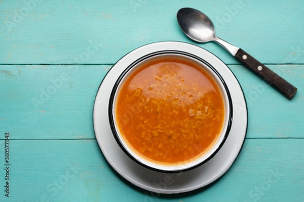 Fototapeta Alphabet soup pasta on turquoise background