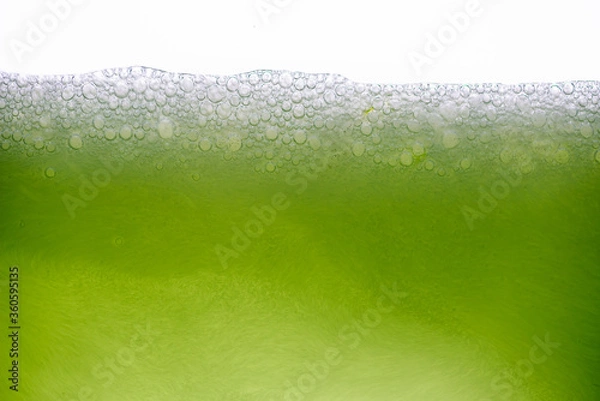 Fototapeta Background of close-up soda bubbles mixed with lemon juice or green juice on white background.