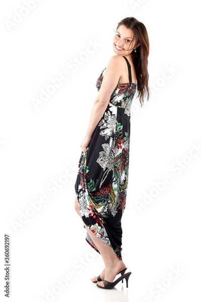 Fototapeta Beautiful young woman in sundress with colorful flower pattern, full body on white background