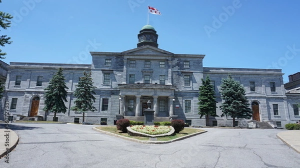 Fototapeta Montreal, QC/ Canada - 6/24/2020: McGill University campus. McGill university flag is on top of McCall MacBain (Arts building) with blue sky in the background.