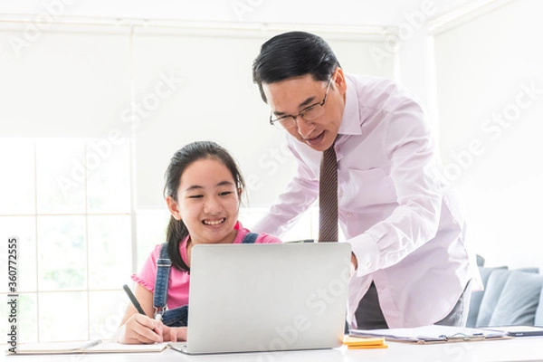 Fototapeta father give advice to daughter while learning from home with laptop on desk. asian family spending time together.