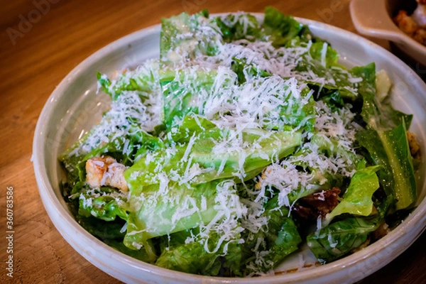 Fototapeta A fresh caesar salad on a wooden table