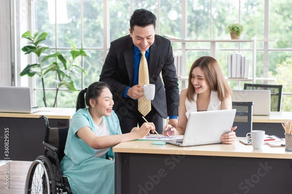 Obraz Asian disabled businesswoman working with the colleague, meeting and consulting feeling happy, smiling and enjoy, working together in the workplace