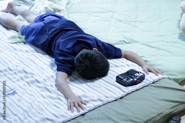 Obraz 夏バテのため布団でダラダラしている小学生の床の子
