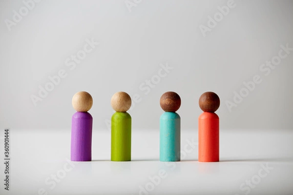 Fototapeta Wooden toy figures concept. Different skin colour people, standing all next to each other, equal to each other. Unknown gender or age.