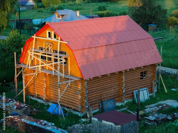 Obraz under construction a two story wooden large log house with a red roof