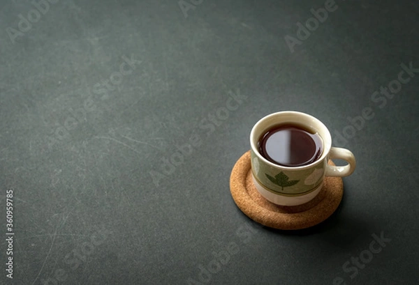 Fototapeta Coffee cup on rustic black tabletop. Top view with copy space.