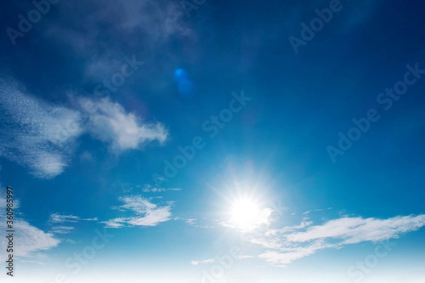 Obraz Beautiful sunny clear blue sky background with sun light rays & spectrum flares shining through soft white cirrocumulus clouds or cirrostratus cloudscape on bright daylight horizon in tropical summer 