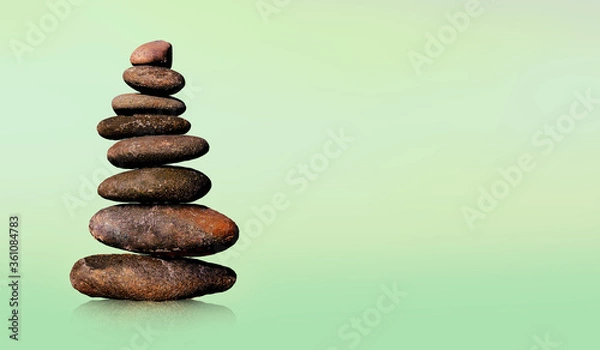 Fototapeta Stone-stacking or rock balancing with green background