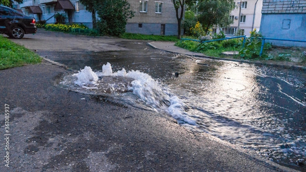 Fototapeta Water flows out of road sewage hatch