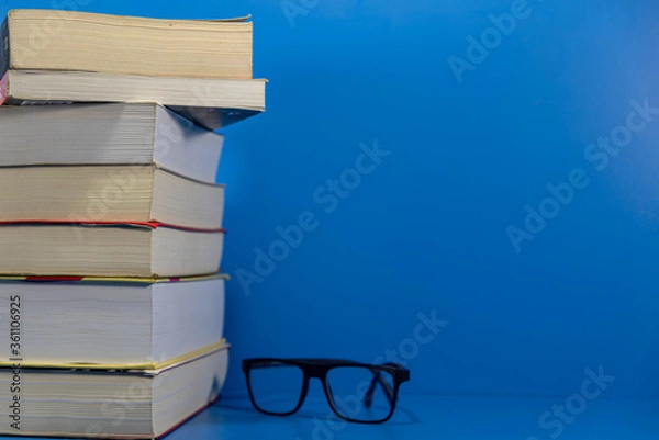 Obraz Stack of paper books on blue background