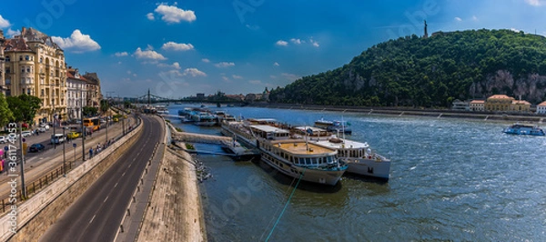 Fototapeta A panorama view across the River Danube in Budapest from the eastern shore to the Gellert Hill and Liberty Statue during summertime