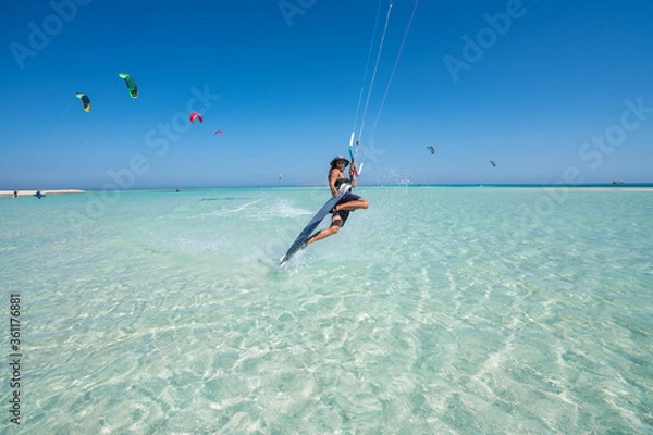 Obraz kiter does a difficult trick on a background of transparent water and blue sky