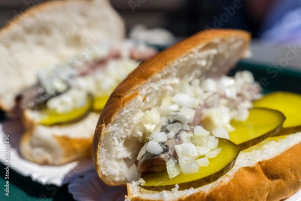 Fototapeta Typical traditional dutch herring sandwich close up macro shot with onions and green pickles and white bread 