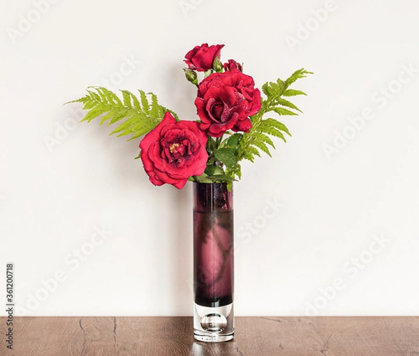 Fototapeta Decorative floral composition of fresh red roses in a vase on the table.