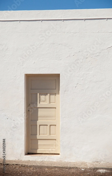 Fototapeta architectural abstract - cream-colored door in a bright white wa