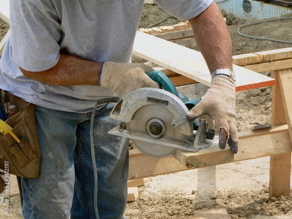 Fototapeta Carpenter with circular saw