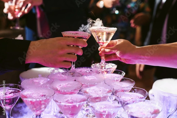 Fototapeta Champagne slide. Pyramid or fountain made of champagne glasses with cherry and steam from dry ice