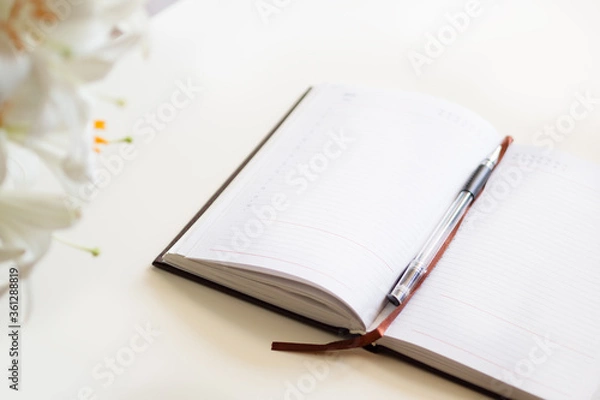 Fototapeta  Open journal, a bouquet of lilies on a white background