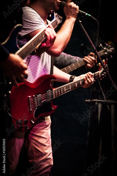 Obraz Three gutairs in gutairists hands in the stage