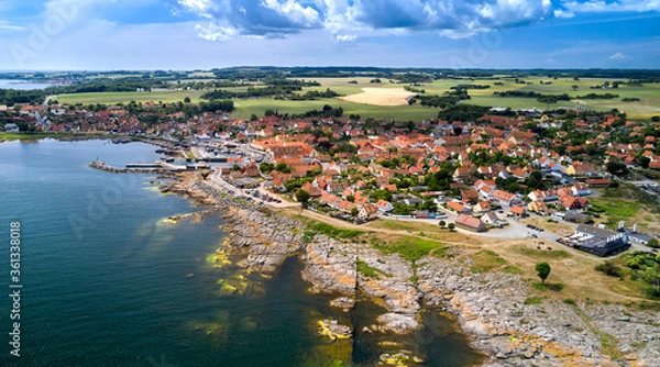 Fototapeta Panorama der dänischen Stadt Svaneke auf der Insel Bornholm an einem Sommertag mit Blick auf die Granitfelsen und Häuser mit roten Dächern.