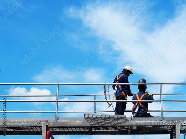 Fototapeta Man Working on the Working at height on construction site with blue sky