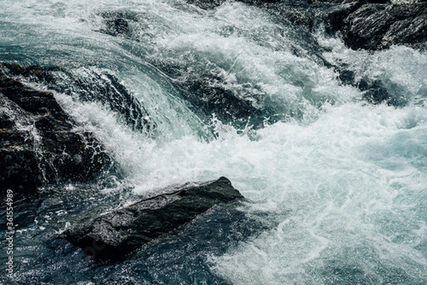 Fototapeta Big rapids of powerful mountain river. Beautiful background with azure water in fast river. Frozen motion of tall mountain river rapids. Power majestic nature of highlands. Backdrop of aqua turbulence