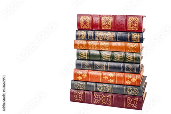 Obraz A stack of leather bound books with golden decoration isolated against a white background.