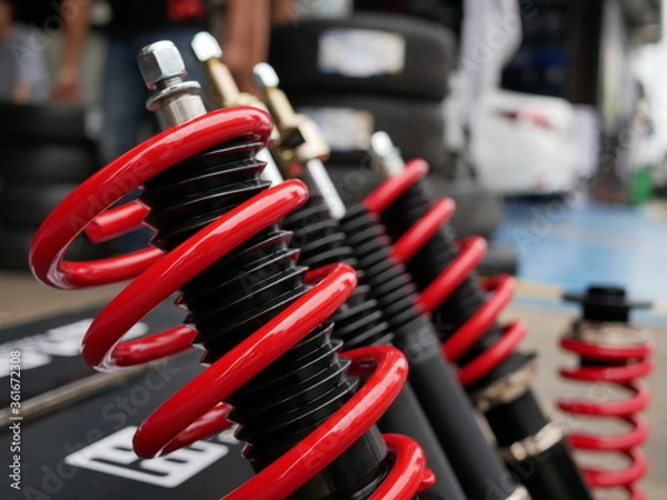 Obraz red shock absorbers of car at garage.