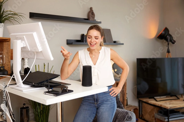 Obraz Smiling Young Beautiful Woman Talking To Smart Speaker